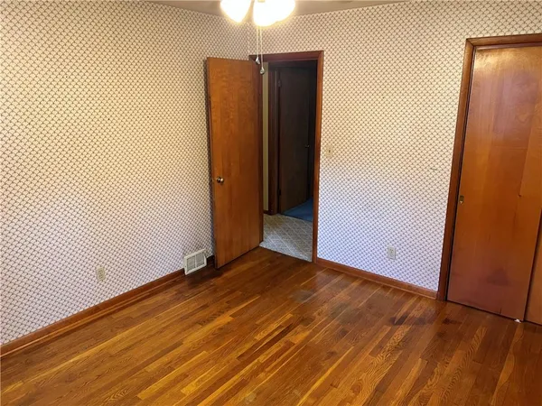an empty room with wooden floor and a window