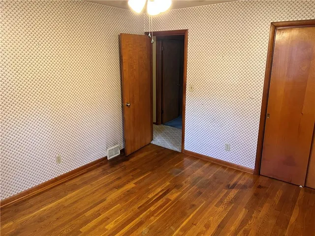 an empty room with wooden floor and a window