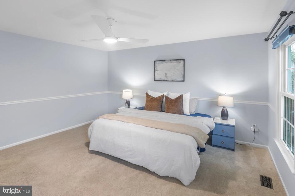 13338 Point Rider Lane Herndon, VA 20171 - Photo 19 of 36 a bedroom with a bed and a lamp