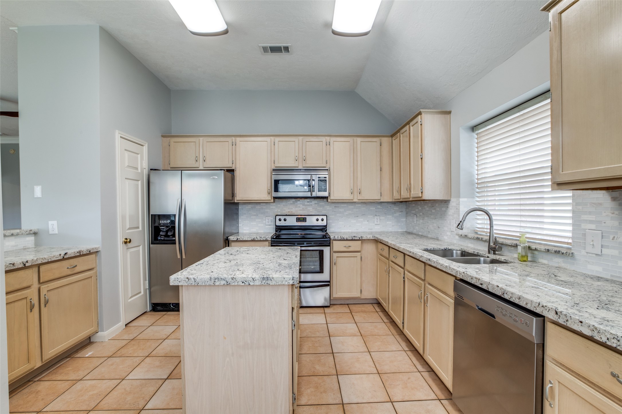 9331 Rodgers Road Houston, TX 77070 - Photo 15 of 25 a kitchen with stainless steel appliances granite countertop a sink stove refrigerator and cabinets