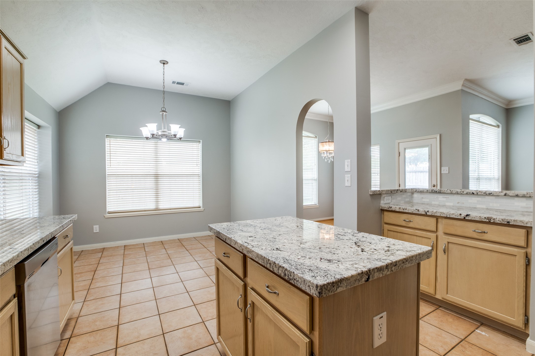 9331 Rodgers Road Houston, TX 77070 - Photo 16 of 25 a kitchen with kitchen island granite countertop a stove a sink cabinetry and chandelier