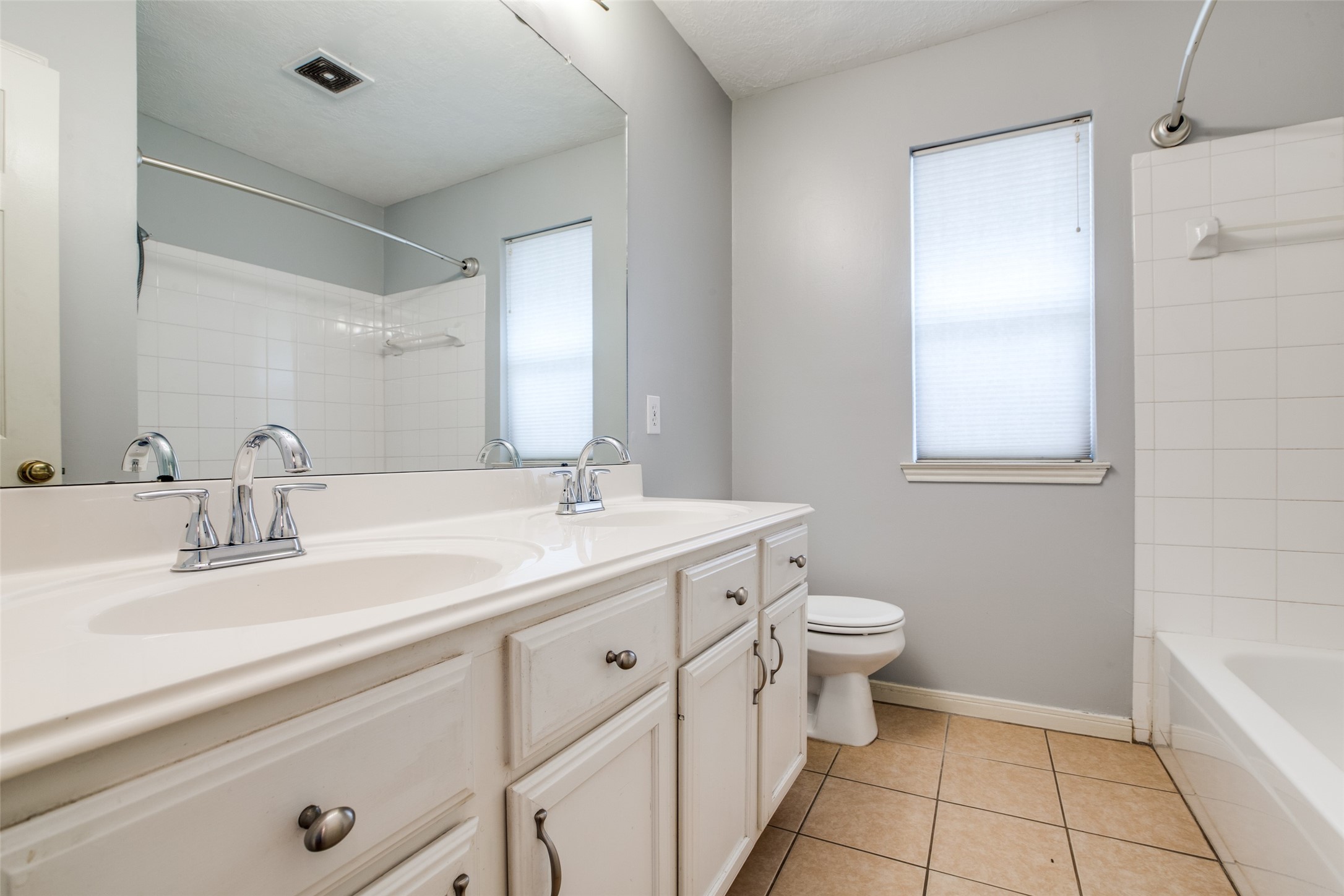 9331 Rodgers Road Houston, TX 77070 - Photo 22 of 25 a bathroom with a double vanity sink toilet and a mirror