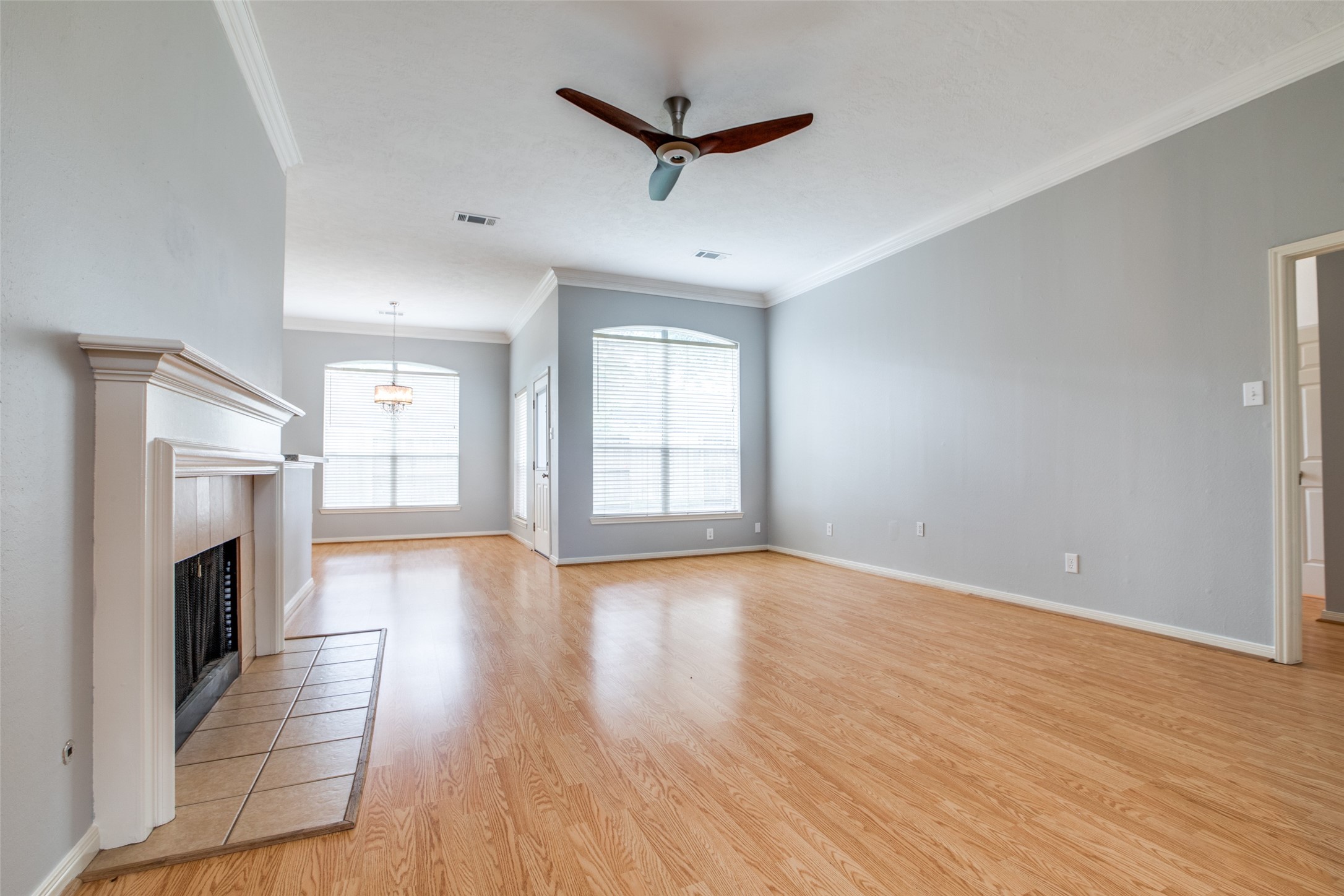 9331 Rodgers Road Houston, TX 77070 - Photo 7 of 25 an empty room with wooden floor a ceiling fan and a window