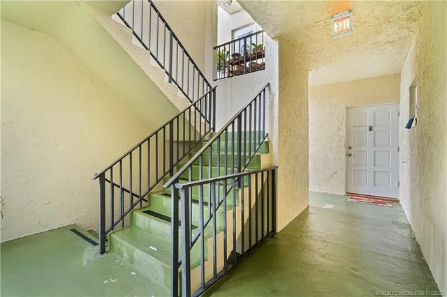 a view of a hallway with wooden floor and door