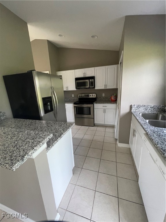 4718 28th Street Southwest Lehigh Acres, FL 33973 - Photo 4 of 12 a kitchen with stainless steel appliances granite countertop a sink and a stove