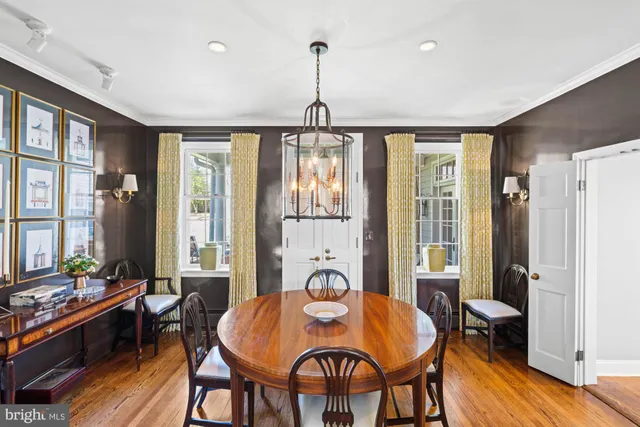 a open kitchen with stainless steel appliances granite countertop a stove a refrigerator a kitchen island a sink dishwasher and white cabinets with wooden floor