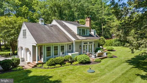 an aerial view of residential house with outdoor space and trees all around