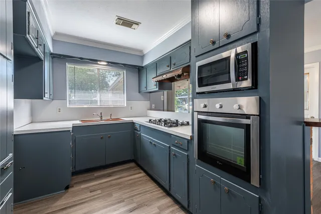 a kitchen with stainless steel appliances granite countertop a stove microwave and sink