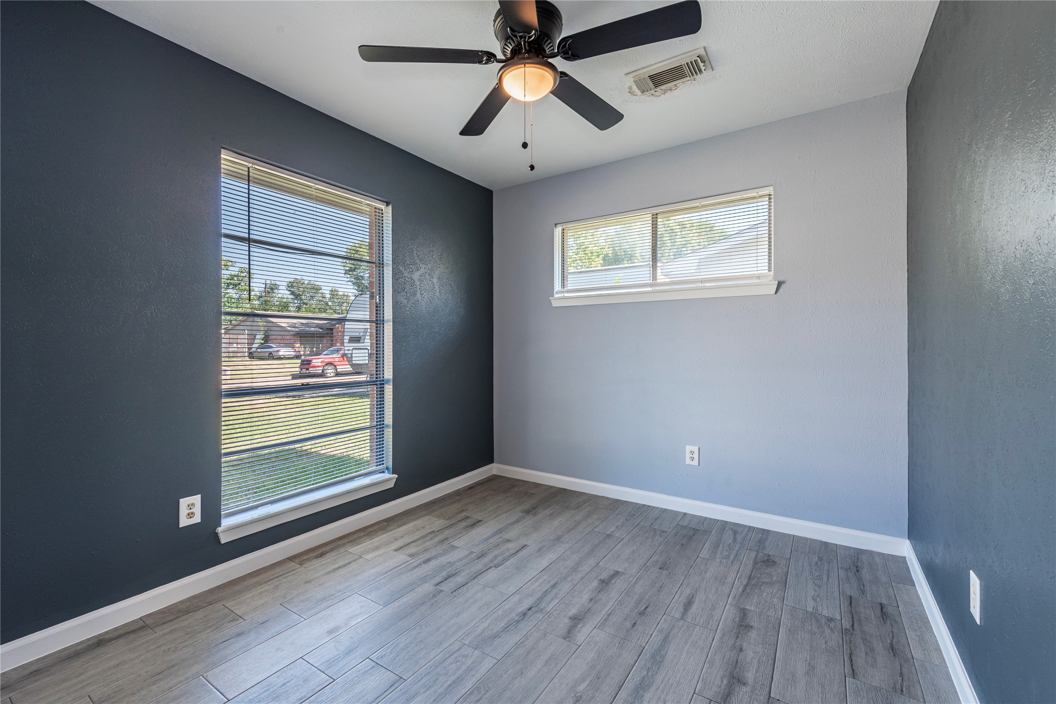 10914 Keese Drive Houston, TX 77089 - Photo 7 of 22 an empty room with wooden floor chandelier fan and windows