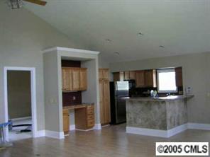 406 Stutts Road Mooresville, NC 28117 - Photo 2 of 8 a kitchen with stainless steel appliances granite countertop a refrigerator a stove and a sink with wooden floor
