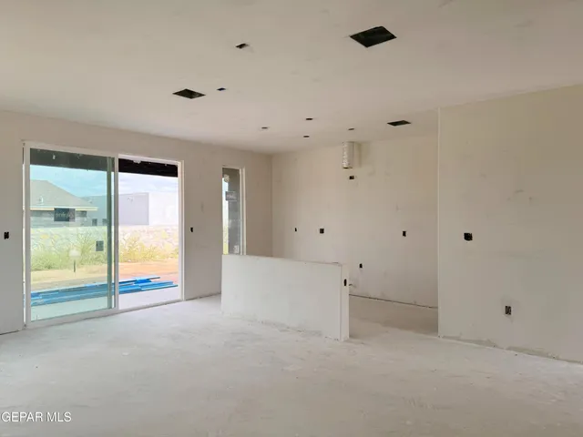 an empty room with sliding glass door and shower