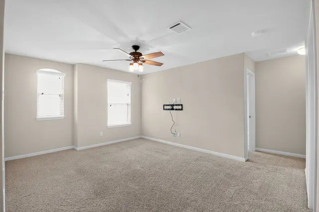 an empty room with closet and a chandelier fan
