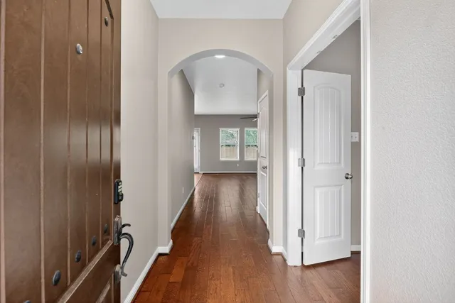 a view of a hallway with wooden floor and staircase