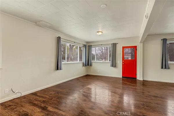 a view of empty room with wooden floor and window