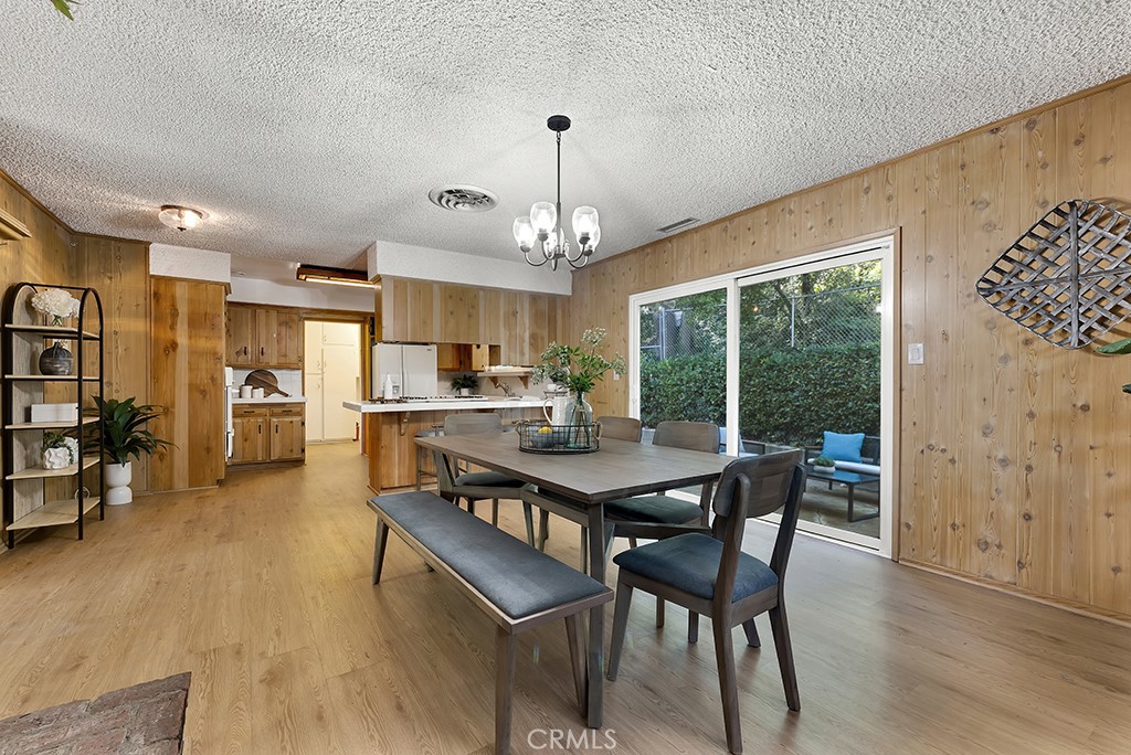4775 Regalo Road Woodland Hills, CA 91364 - Photo 16 of 42 a dining room with furniture a chandelier and wooden floor