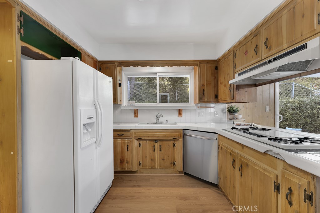 4775 Regalo Road Woodland Hills, CA 91364 - Photo 20 of 42 a kitchen with stainless steel appliances granite countertop a sink and a refrigerator