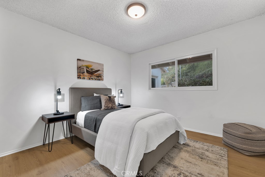 4775 Regalo Road Woodland Hills, CA 91364 - Photo 27 of 42 a bedroom with a bed and a painting on the wall