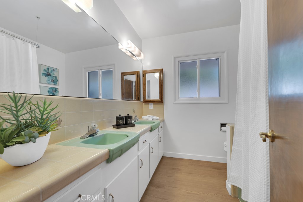 4775 Regalo Road Woodland Hills, CA 91364 - Photo 28 of 42 a bathroom with a granite countertop sink a mirror and a shower