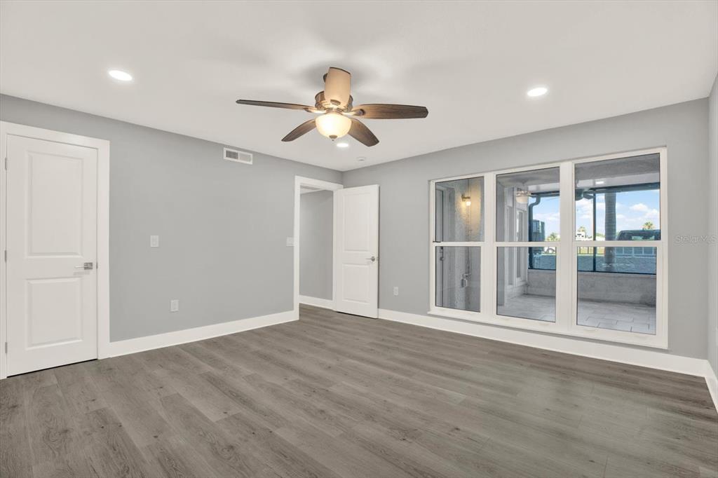 337 Rex Place, Unit A Madeira Beach, FL 33708 - Photo 21 of 48 a view of an empty room with wooden floor and a ceiling fan