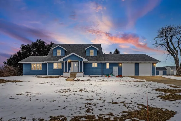 a front view of a house with a yard covered in snow