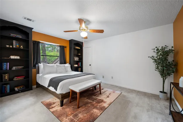 a bedroom with a bed chandelier and a window