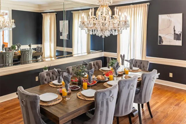 a view of a dining room with furniture a chandelier and wooden floor