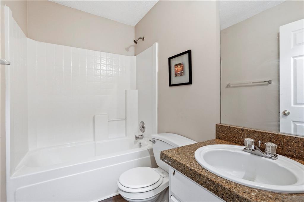 1300 Sunflower Court Locust Grove, GA 30248 - Photo 16 of 24 a bathroom with a toilet a sink and a bathtub