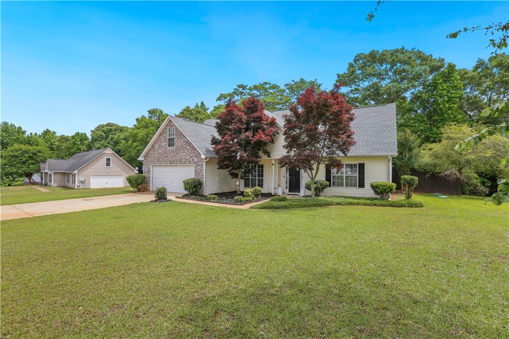1300 Sunflower Court Locust Grove, GA 30248 - Photo 3 of 24 a view of a house with a yard and garage