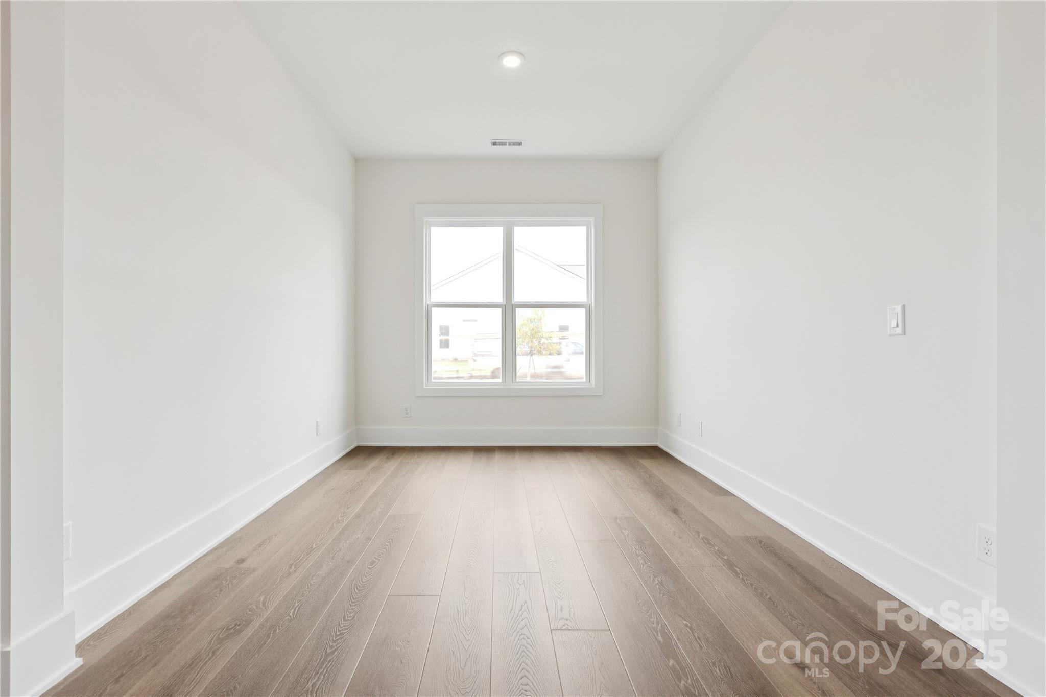 4334 Durango Drive, Unit 265 Indian Land, SC 29707 - Photo 10 of 28 an empty room with wooden floor and windows