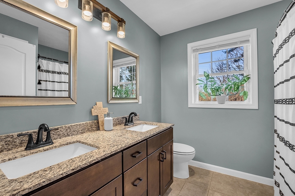 261 Bean Porridge Hill Road Westminster, MA 01473 - Photo 21 of 33 a bathroom with a granite countertop sink a toilet and a window