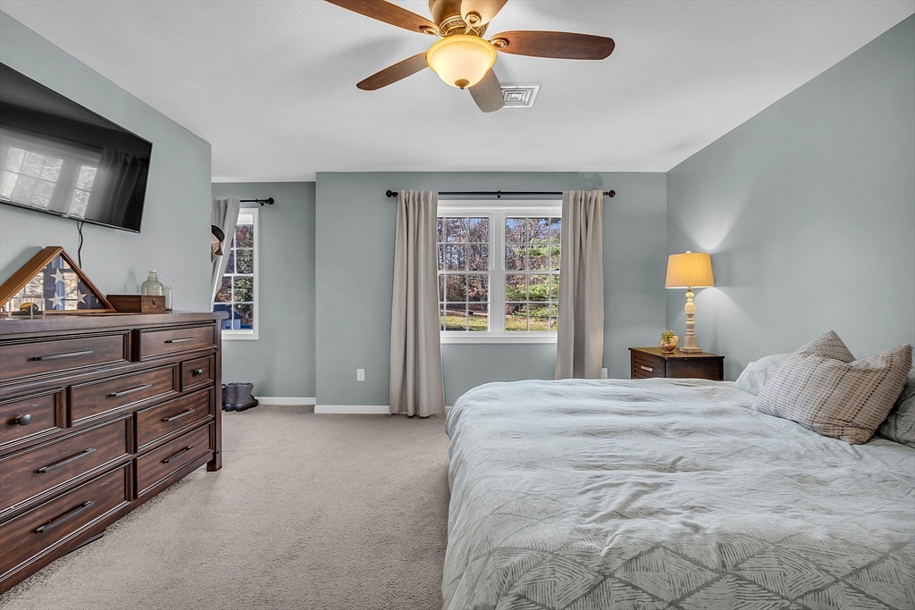 261 Bean Porridge Hill Road Westminster, MA 01473 - Photo 24 of 33 a bedroom with a bed and a chandelier