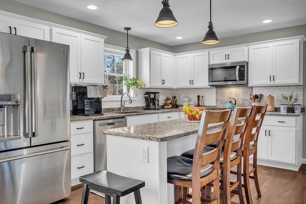 261 Bean Porridge Hill Road Westminster, MA 01473 - Photo 6 of 33 a kitchen with stainless steel appliances granite countertop a refrigerator a stove a sink a dining table and chairs with wooden floor