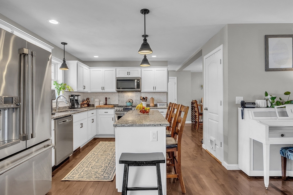 261 Bean Porridge Hill Road Westminster, MA 01473 - Photo 9 of 33 a kitchen with stainless steel appliances granite countertop a stove refrigerator a sink dishwasher a dining table and chairs with wooden floor
