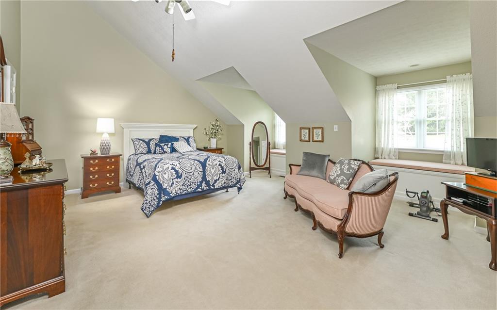 216 Sycamore Drive Seven Fields, PA 16046 - Photo 18 of 25 a spacious bedroom with a bed a couch and a dresser next to a window
