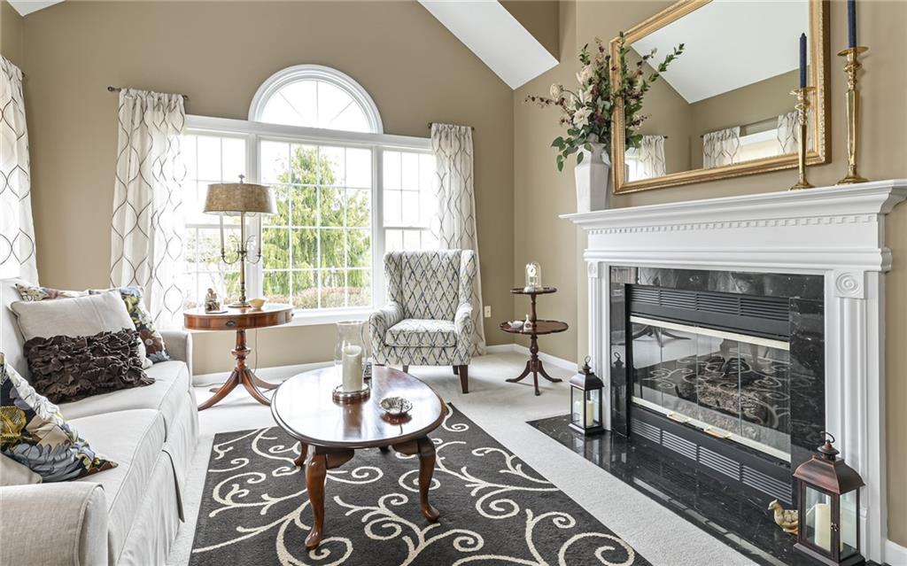 216 Sycamore Drive Seven Fields, PA 16046 - Photo 5 of 25 a living room with furniture a fireplace and a floor to ceiling window
