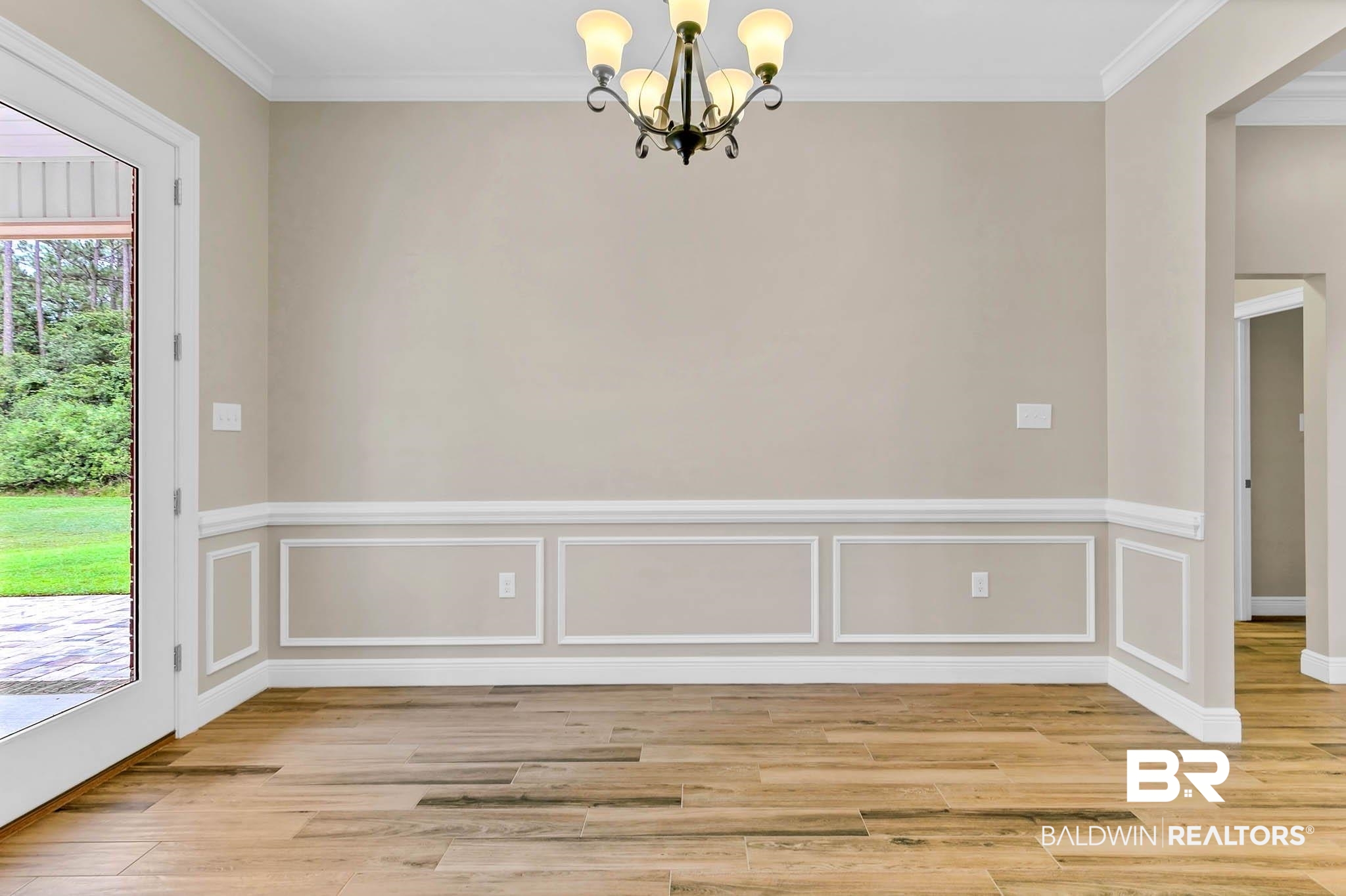 8145 Bay View Drive Foley, AL 36535 - Photo 16 of 81 Unfurnished dining area with a chandelier, light wood finished floors, crown molding, and wainscoting