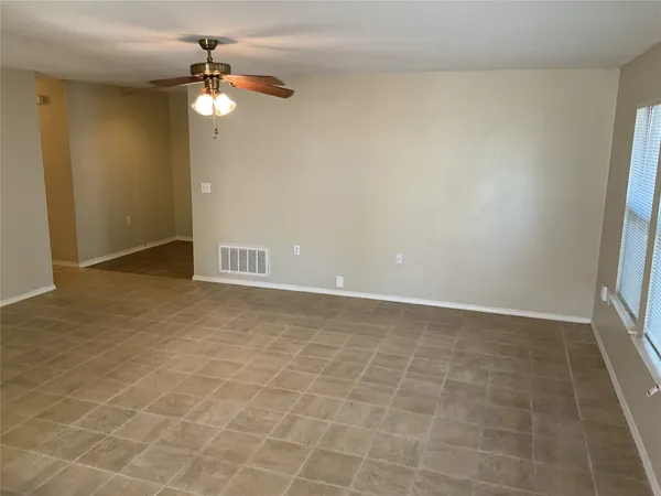 an empty room with a chandelier fan