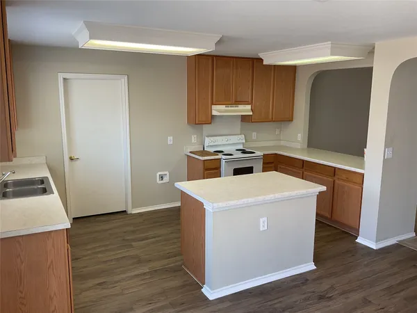 a view of a kitchen with wooden floor and electronic appliances
