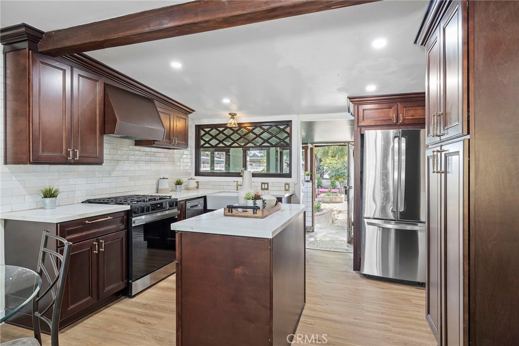 12428 Pasadena Street Whittier, CA 90601 - Photo 10 of 25 a kitchen with stainless steel appliances granite countertop a sink a stove and a refrigerator