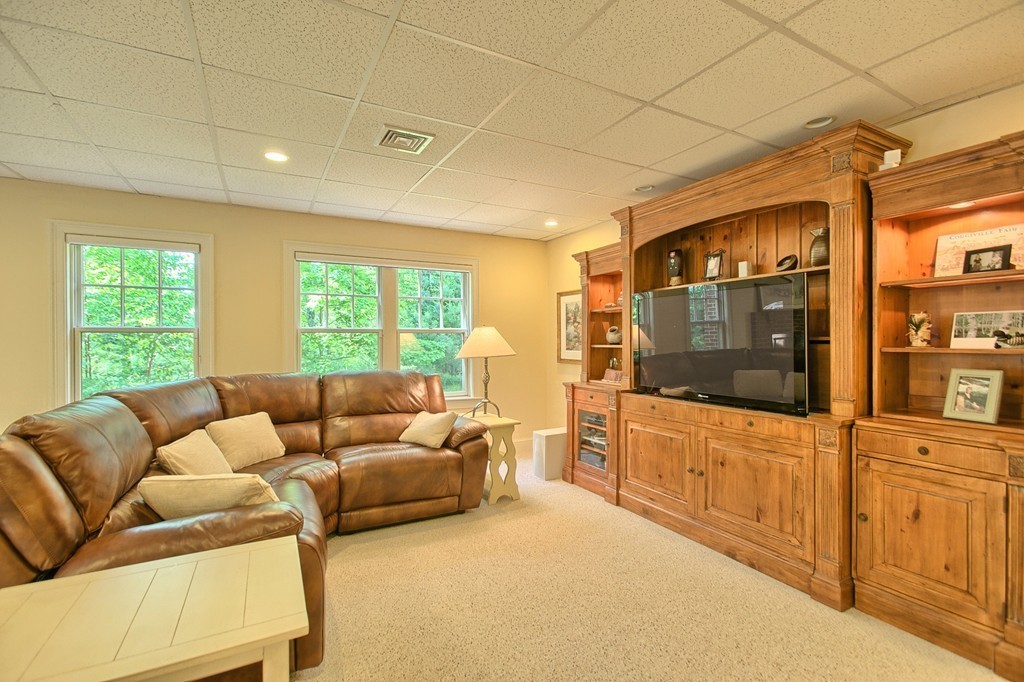96 Forest Ridge Road, Unit 96 Concord, MA 01742 - Photo 22 of 24 a living room with furniture and a flat screen tv
