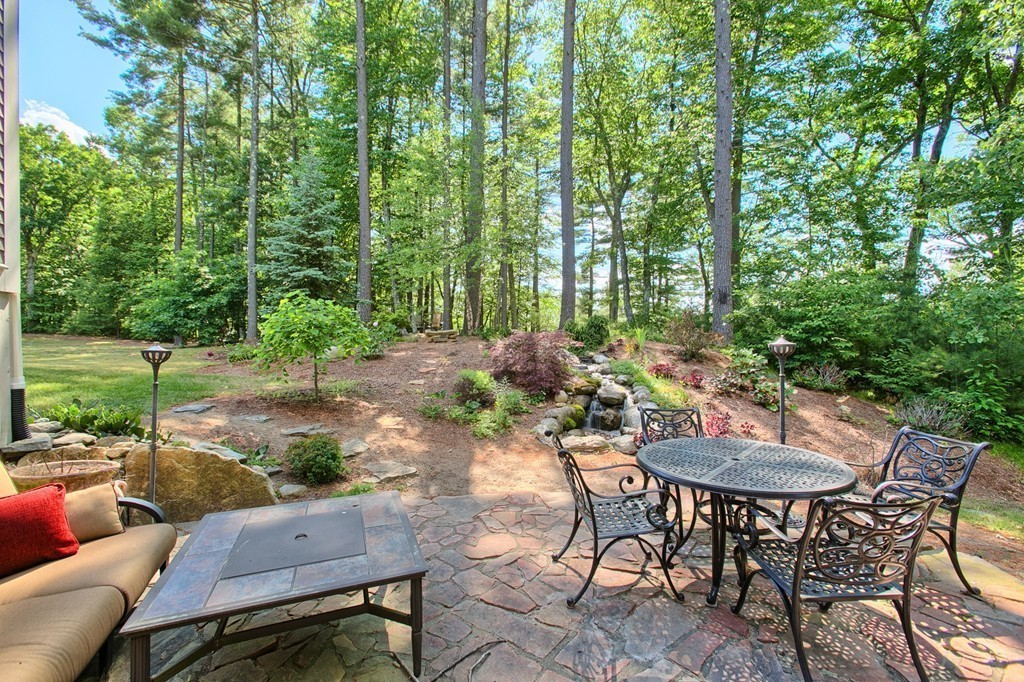 96 Forest Ridge Road, Unit 96 Concord, MA 01742 - Photo 3 of 24 a backyard of a house with table and chairs