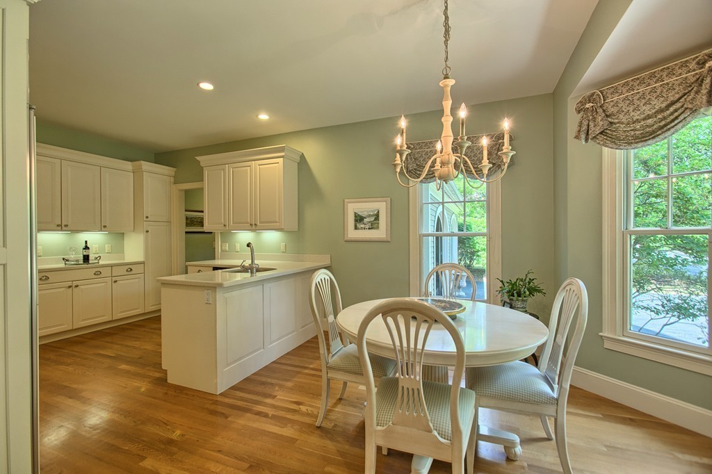 96 Forest Ridge Road, Unit 96 Concord, MA 01742 - Photo 5 of 24 a kitchen with microwave a stove and wooden cabinets