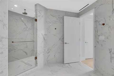 a bathroom with a shower and a glass door