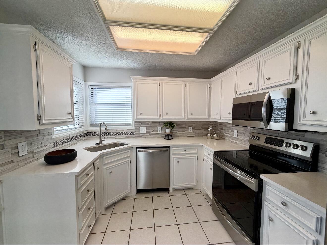 2318 94th Street Lubbock, TX 79423 - Photo 4 of 19 a kitchen with a sink stove top oven and cabinets