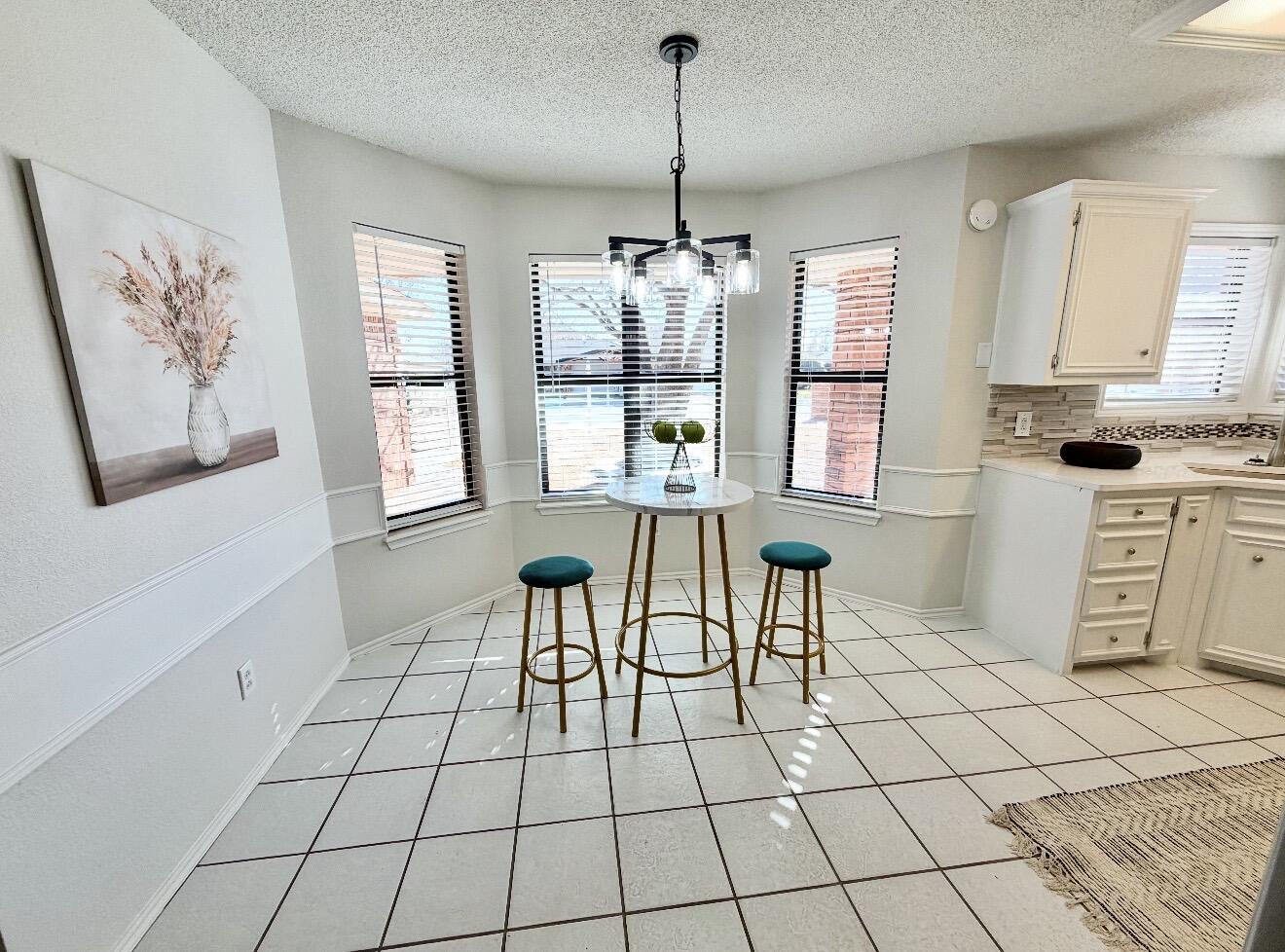 2318 94th Street Lubbock, TX 79423 - Photo 7 of 19 a view of kitchen with windows cabinets and wooden floor
