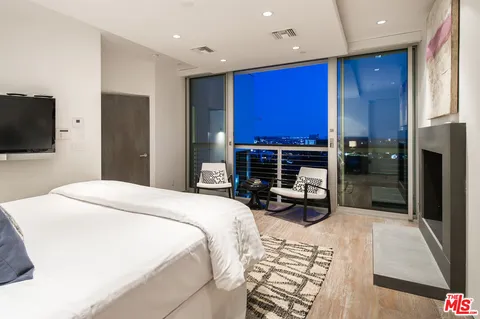 a bed room with a bed a television and a large window