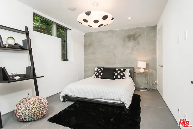 a bedroom with a bed and a painting on the wall