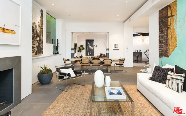 a living room with furniture and floor to ceiling windows