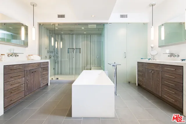 a bathroom with a double vanity sink a mirror and a bathtub