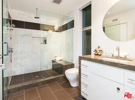a bathroom with a granite countertop sink toilet a mirror and shower